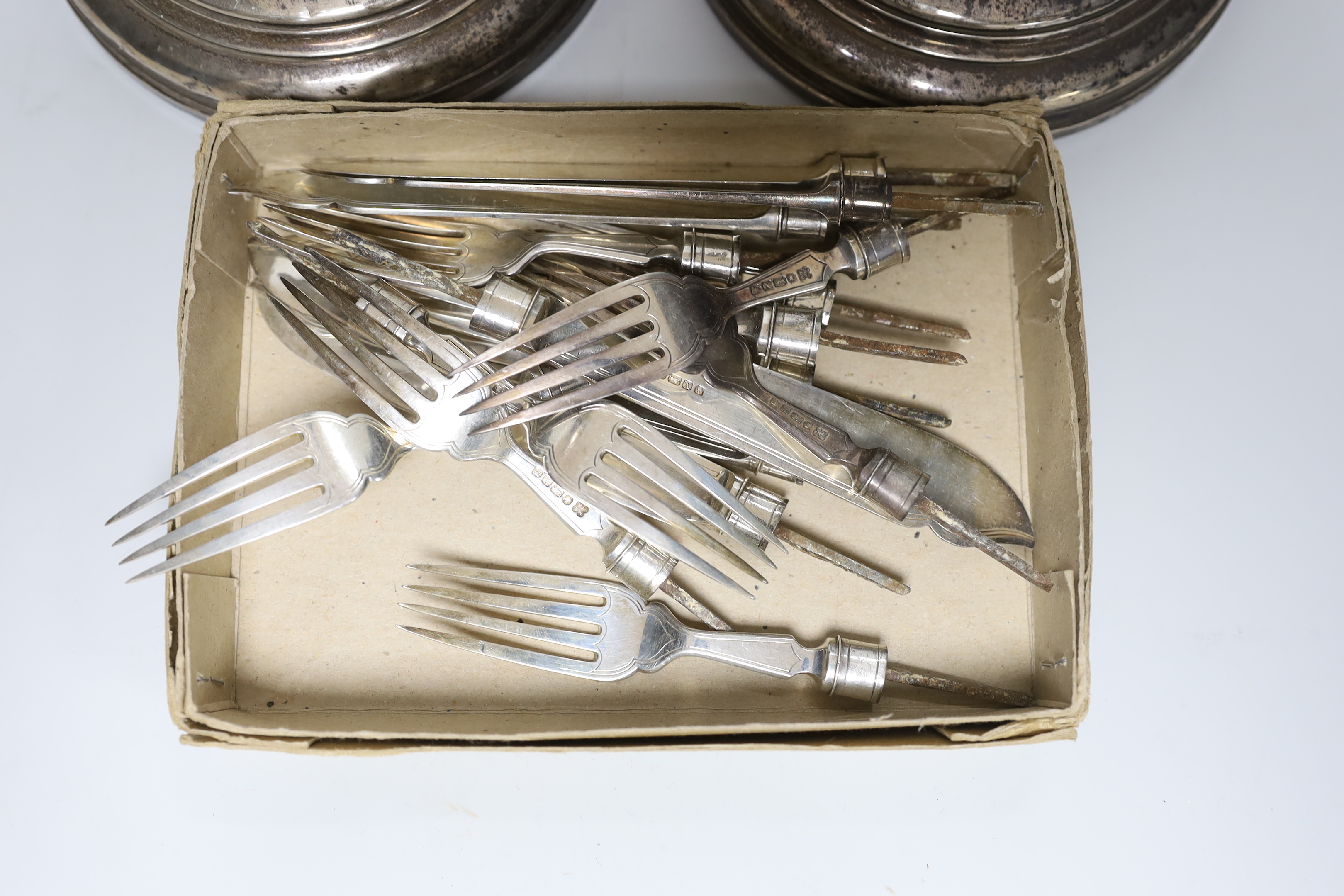 A pair of George V silver candlesticks, by William Comyns & Sons Ltd, London, 1930, height 29.6cm, weighted and eight pairs of silver fish eaters (no handles).